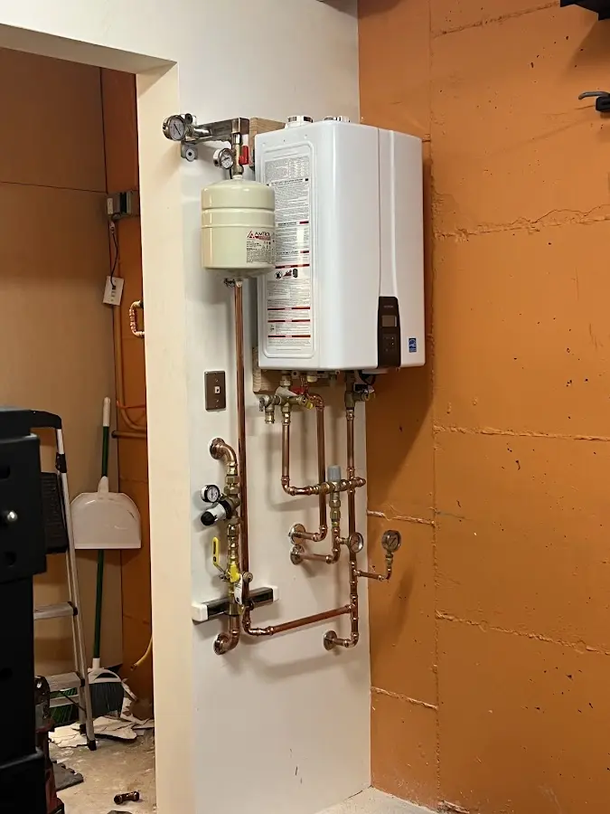 Plumbing technician inspecting water heater connections in El Dorado
